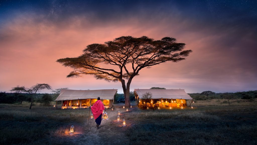 Serengeti Under Canvas Tanzania Guest Area camp exterior with lantern walkway and Maasai
